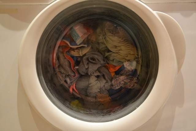 hublot d'une machine à laver remplie de linge sale