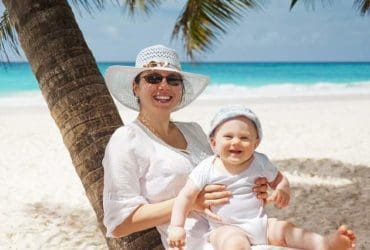 Maman protégeant son bébé du soleil sur une belle plage