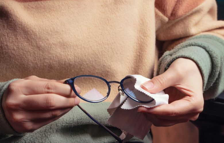 Un homme nettoyant ses lunettes